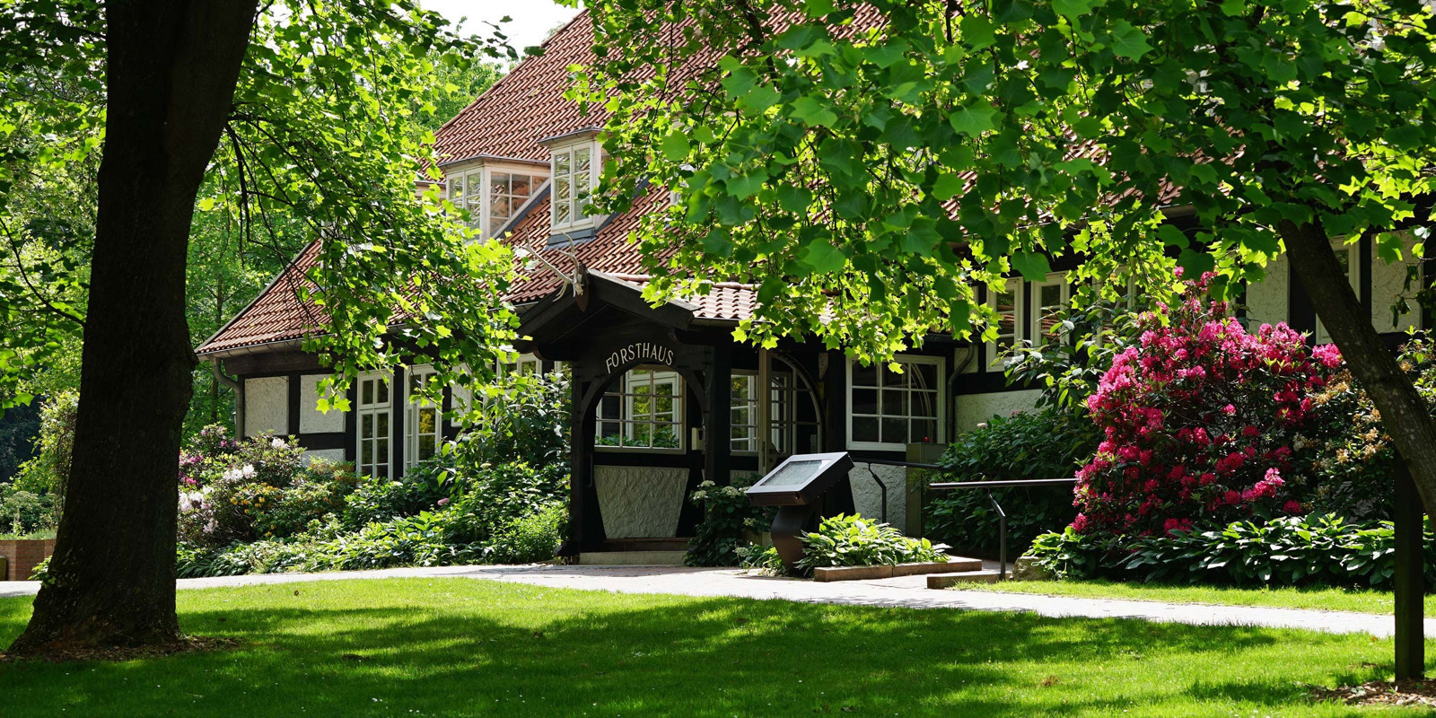 Das Forsthaus Heiligenberg – Fachwerkhaus zwischen alten Bäumen und blühenden Rhododendren