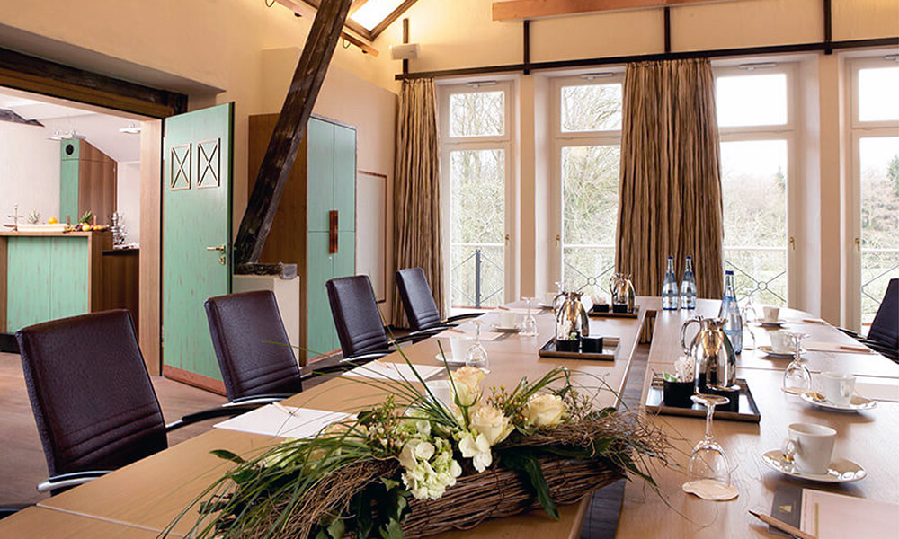 Heller Tagungsraum im Forsthaus Heiligenberg mit langer Tafel und Blick ins Grüne