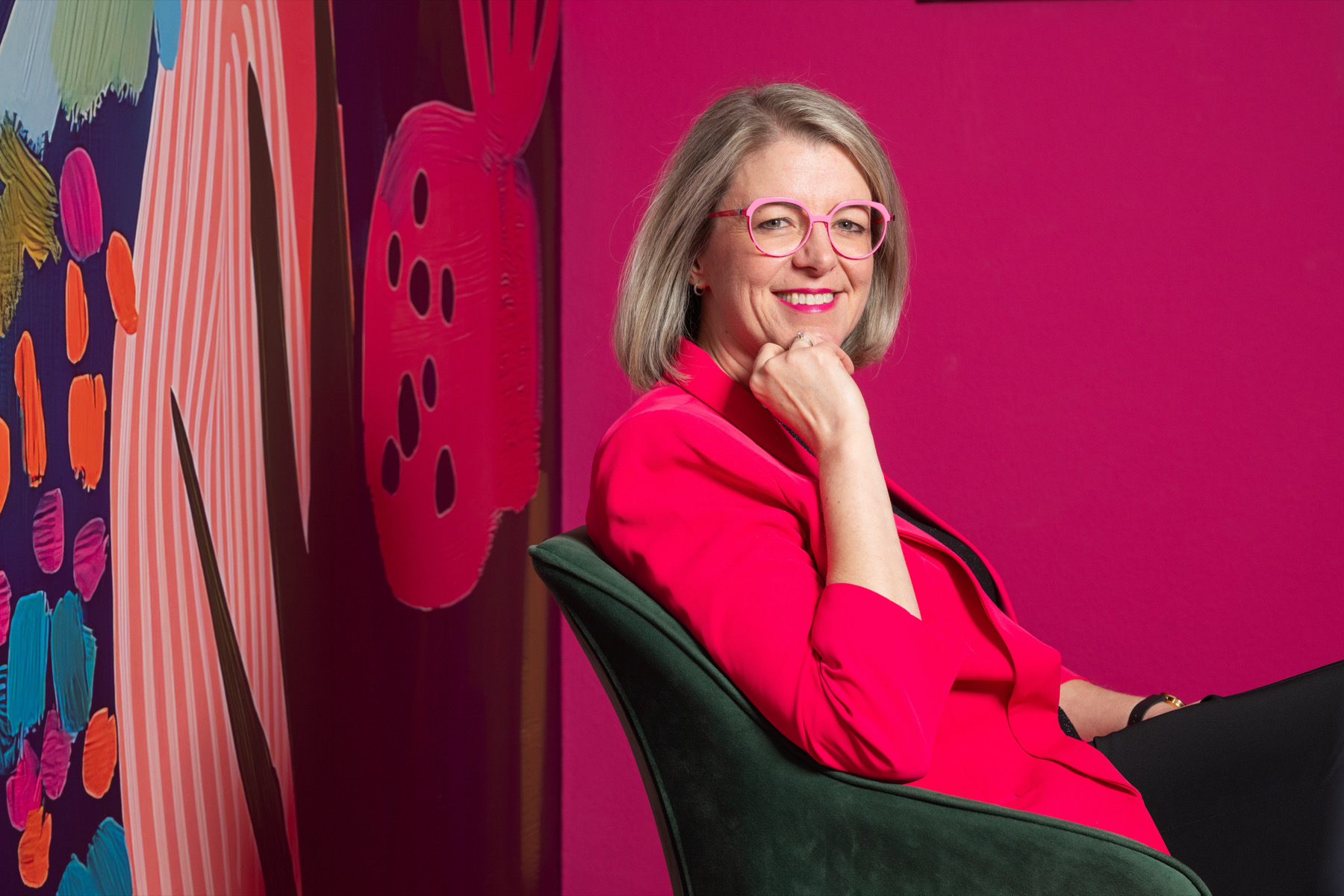 Rebecca Maria Jesske, Speakerin und Mentorin für Charisma, im pinken Blazer vor pinker Wand