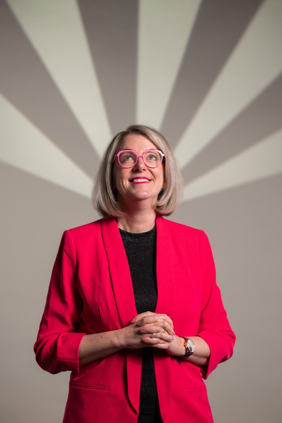 Rebecca Maria Jesske, Speakerin und Mentorin, im Studioporträt vor grafischem Hintergrund